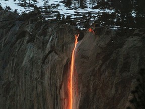 In this Feb. 16, 2010, file photo, a shaft of sunlight creates a glow near Horsetail Fall, in Yosemite National Park, Calif. Mother Nature is again putting on a show at California’s Yosemite National Park, where every February the setting sun draws a narrow sliver on a waterfall to make it glow like a cascade of molten lava. The phenomenon known as “firefall” draws scores of photographers to the spot, which flows down the granite face of the park’s famed rock formation, El Capitan. (Eric Paul Zamora/The Fresno Bee via AP, File)