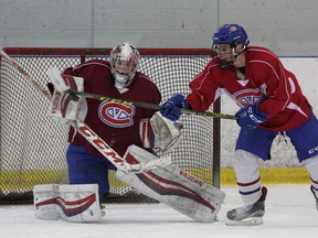 Kingston Voyageurs’ Cole Edwards tries to deflect a shot in front of goaltender Zach Springer during practice at the Invista Centre on Tuesday. (Ian MacAlpine/The Whig-Standard)