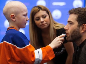 Edmonton Oilers defenceman Eric Gryba has his beard shaved by Ethan Hughes, 10, for charity, at Rogers Place in Edmonton Wednesday Feb. 15, 2017. Gryba was raising awareness for Garth Brooks' Teammates for Kids Foundation. Helping Ethan is Farrah Hart from Tommy Gun's Original Barbershop