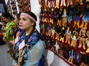 Student Rebecca Young, 21, stands near some of the 600 faceless felt dolls at a ceremony Wednesday at Fanshawe College in London. The dolls were created by Fanshawe students to raise awareness of missing and murdered indigenous women. (MORRIS LAMONT, The London Free Press)