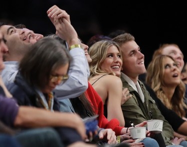 Genie Bouchard, left, poses for photographs with her blind date, John Goehrke, right, during the second half of an NBA basketball game between the Brooklyn Nets and the Milwaukee Bucks Wednesday, Feb. 15, 2017, in New York. (AP Photo/Frank Franklin II)
