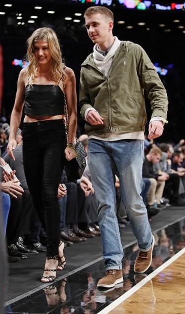 Genie Bouchard, walks the court with her blind date, John Goehrke, right, during the first half of an NBA basketball game between the Brooklyn Nets and the Milwaukee Bucks Wednesday, Feb. 15, 2017, in New York. (AP Photo/Frank Franklin II)