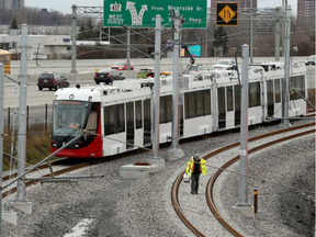 A light-rail transit (LRT) line worker walks the tracks near the Cyrville station as the first Confederation Line O-Train vehicle assembled in Ottawa prepares to move along the tracks. (Julie Oliver, Postmedia)