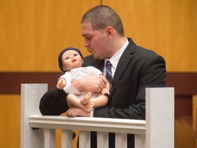 Tony Moreno demonstrates to the jury how he held his son Aaden on the railing of the Arrigoni Bridge in the final moments of Aaden's life, during Moreno's trial Thursday, Feb. 16, 2017, in Middletown, Ct. Moreno's attorney Norman A. Pattis, left, questions Moreno who took the witness stand on Thursday morning in the fourth day of his murder trial at Middlesex Superior Court. Moreno is charged with murder and risk of injury to a child and is accused of throwing 7-month-old Aaden Moreno to his death from the Arrigoni Bridge on July 5, 2015. Moreno denies intentionally killing his son. (Patrick Raycraft/Hartford Courant via AP, Pool)