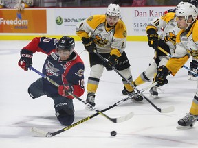 Windsor Spitfires forward Jeremiah Addison, left, backhands a shot against Sarnia Sting teammates Troy Lajeunesse, Jordan Ernst and Connor Schlichting in OHL action from WFCU Centre Wednesday. The Sting lost 6-3. (NICK BRANCACCIO/Windsor Star)