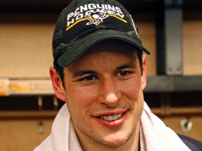 Pittsburgh Penguins' Sidney Crosby holds the puck honoring the 1,000th point in his NHL career, in the locker room after scoring in overtime of the team's NHL game against the Winnipeg Jets in Pittsburgh on Feb. 16, 2017. (AP Photo/Gene J. Puskar)