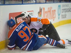 Connor McDavid of the Edmonton Oilers sits on the ice with a broken left clavicle after getting hit into the boards by Brandon Manning of the Philadelphia Flyers at Rexall Place on Nov. 3, 2015. (Shaughn Butts)