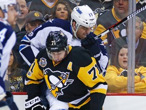 Penguins Evgeni Malkin tangles with Jets forward Adam Lowry Thursday in Pittsburgh.