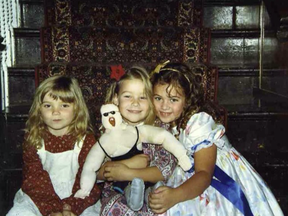 From left, Neidhart sisters Muffy, Nattie and Jenni sit on a staircase in Calgary's Hart House in an undated photo. Nattie is holding a doll of her father, Jim 'The Anvil' Neidhart, made by her mother, Ellie Hart.
