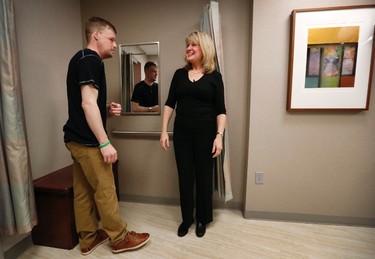 In this Jan. 24, 2017 photo, face transplant recipient Andy Sandness talks with physical therapist Helga Smars, right, during an appointment at the Mayo Clinic in Rochester, Minn. His facial muscles are growing stronger. He received speech therapy to learn to use his tongue in a new mouth and jaw and enunciate clearly. He's thrilled to smell again, breathe normally and be eating foods that were off-limits for a decade: apples, steak and pizza that he shared with his doctors. (AP Photo/Charlie Neibergall) ORG XMIT: NY497