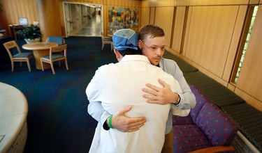 In this Jan. 25, 2017, photo, face transplant recipient Andy Sandness is hugged by Dr. Samir Mardini, foreground, during a visit to the Saint Marys Hospital campus at the Mayo Clinic in Rochester, Minn. Mardini led a medical team to perform Sandness' face transplant surgery, the first performed at the medical center. (AP Photo/Charlie Neibergall) ORG XMIT: NY498