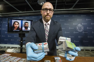 Detective Constable Micheal Lane displays hundreds of pieces of credit card fraud and Identity fraud part of a of a multi-million-dollar Fraud and money -laundering investigation on Friday February 17, 2017. (Craig Robertson/Toronto Sun)
