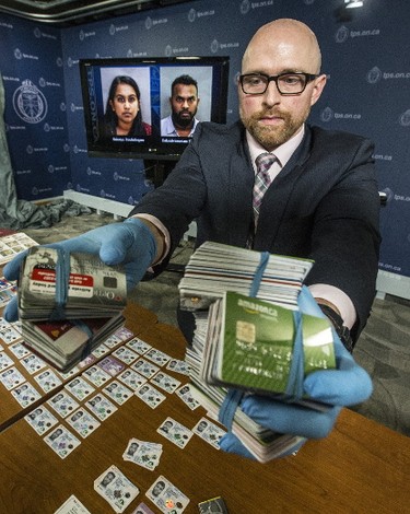 Detective Constable Micheal Lane displays hundreds of pieces of credit card fraud and Identity fraud part of a of a multi-million-dollar Fraud and money -laundering investigation on Friday February 17, 2017. (Craig Robertson/Toronto Sun)