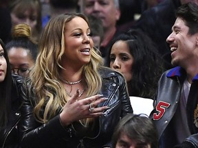 Singer Mariah Carey, left, talks with Bryan Tanaka during the second half of an NBA basketball game between the Los Angeles Clippers and the Atlanta Hawks, Wednesday, Feb. 15, 2017, in Los Angeles. The Clippers won 99-84. (AP Photo/Mark J. Terrill)