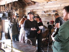 Sarnia-based director Aaron Huggett gives direction to crew members during the filming of a new Black Donnellys movie in Napier Friday. An 80-member cast and crew started work on the Eclipse Media production this weekend, filming scenes in an 1850s-era log cabin in Napier, as well as scenes in Lucan. Barbara Simpson/Sarnia Observer/Postmedia Network