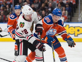 Brandon Davidson (88)of the Edmonton Oilers, pushes Artemi Panarin of the Chicago Blackhawks off the puck at Rogers Place in Edmonton on Feb. 11, 2017.