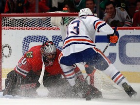 Chicago Blackhawks goalie Corey Crawford (50) stops the shot of Edmonton Oilers center Ryan Nugent-Hopkins (93) during the first period of an NHL hockey game Saturday, Feb. 18, 2017, in Chicago.