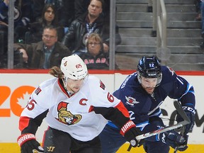 WINNIPEG, CANADA - MARCH 4: Erik Karlsson #65 of the Ottawa Senators and Drew Stafford #12 of the Winnipeg Jets chase after the loose puck during third period action on March 4, 2015 at the MTS Centre in Winnipeg, Manitoba, Canada. (Photo by Lance Thomson/NHLI via Getty Images)