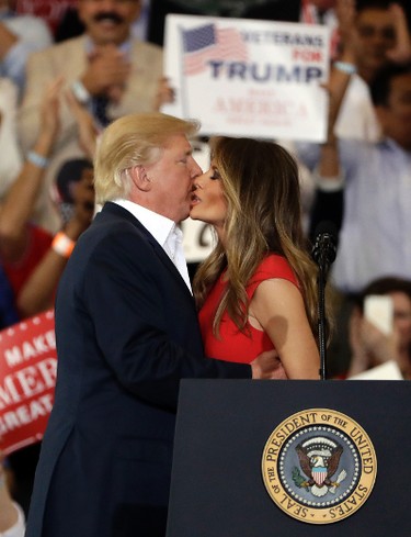 U.S. President Donald Trump kisses his wife, first lady, Melania Trump, during the "Make America Great Again Rally" at Orlando-Melbourne International Airport Saturday, Feb. 18, 2017, in Melbourne, Fla. (AP Photo/Chris O'Meara)