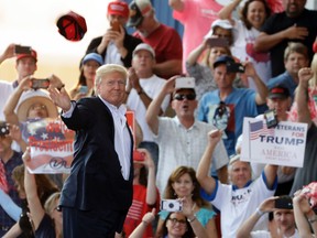 U.S. President Donald Trump throws a hat into the crowd during the "Make America Great Again Rally" at Orlando-Melbourne International Airport Saturday, Feb. 18, 2017, in Melbourne, Fla. (AP Photo/Chris O'Meara)