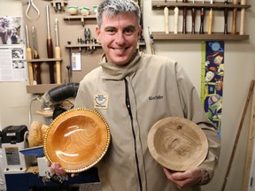 Quinte Woodturners Guild member, David Wheeler holds up one of his finished pieces alongside an in-progress piece on Friday February 17, 2017 in Trenton, Ont. Guild members will be donating more than 40 hand-crafted wooden bowls to the Empty Bowls fundraiser at Loyalist College. Proceeds from the event will go towards eight foodbanks in the region. Tim Miller/Belleville Intelligencer/Postmedia Network