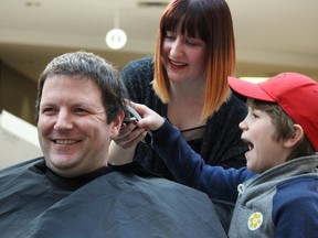 Gavin Cooper, 6, can't control his excitement shaving his father Mark, a Sarnia firefighter, at the Shave for the Brave event held at Lambton Mall Sunday. More than 20 Sarnia-Lambton first responders went under the clippers to raise $15,000 for pediatric cancer research. Pictured here with the Coopers is hairdresser Jessica Daborn, of Trendsetters Hair Studio. Barbara Simpson/Sarnia Observer/Postmedia Network