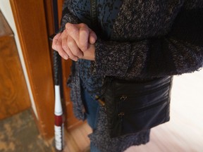 Kathy Bullock poses for a photo in her east Edmonton home, Thursday Feb. 16, 2017. Bullock  now keeps a baseball bat beside her front door after a Feb. 11 incident where her purse was snatched inside the Capilano Safeway. Photo by David Bloom