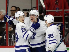 Toronto Maple Leafs' Auston Matthews, center, is congratulated by Nikita Zaitsev (22), of Russia, and Roman Polak (46), of the Czech Republic, following Matthews' goal against the Carolina Hurricanes during the second period of an NHL hockey game in Raleigh, N.C., Sunday, Feb. 19, 2017. (AP Photo/Gerry Broome
