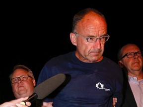Douglas Garland is escorted into a Calgary police station on Monday, July 14, 2014. (THE CANADIAN PRESS/Jeff McIntosh)