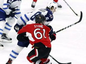 Ottawa Senators' Mark Stone (61) is hit hard by Winnipeg Jets' Jacob Trouba (8) during third period NHL hockey action in Ottawa on, Sunday February 19, 2017. THE CANADIAN PRESS/Fred Chartrand
