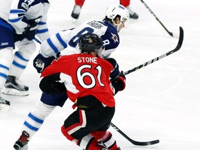 Ottawa Senators' Mark Stone (61) is hit hard by Winnipeg Jets' Jacob Trouba (8) during third period NHL hockey action in Ottawa on, Sunday Feb. 19, 2017. THE CANADIAN PRESS/Fred Chartrand