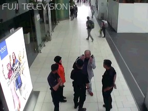 In this image made from Feb. 13, 2017, airport closed circuit television video and provided by Fuji Television, Kim Jong Nam, exiled half-brother of North Korea's leader Kim Jong Un, gestures towards his face while talking to airport security and officials at Kuala Lumpur International Airport, Malaysia. Kim Jong Nam, the estranged half brother of North Korean ruler Kim Jong Un, died last week after apparently being poisoned in a Kuala Lumpur airport. (Fuji Television via AP)