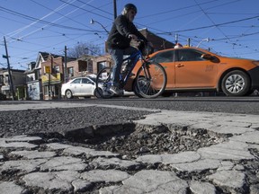 Potholes at the intersection of Coxwell Ave. and Queen St. E. on Sunday, February 19, 2017. (Craig Robertson/Toronto Sun)