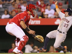 Jose Altuve #27 of the Houston Astros slides in safely to score a run ahead of the throw to catcher Juan Graterol #57 of the Los Angeles Angels of Anaheim in the seventh inning at Angel Stadium of Anaheim on Oct. 1, 2016 in Anaheim, Calif.  (Stephen Dunn/Getty Images File Photo)