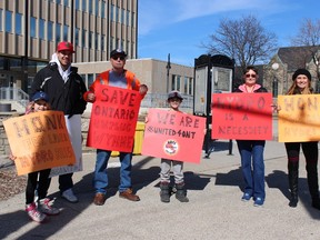 The Bell family protests outside of Sarnia city hall Monday afternoon in an effort to draw attention to soaring hydro bills in Ontario. More than 20 different Ontario cities and towns played host to HOPE protests Monday organized by the Fix This Crisis Now Facebook group. Pictured here, from left to right, are Riley Meade, 6, Cecil Bell, Matthew Goulais, Dylan Meade, 8, Diane Bell and Samantha Meade. Barbara Simpson/Sarnia Observer/Postmedia Network