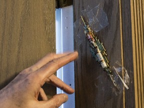 A tenant tape up a replacement mezuzah on Monday February 20, 2017 after his was taken from a condo door at 233 Beecroft. (Craig Robertson/Toronto Sun)