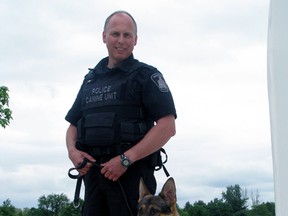 Const. Wayne Sczepanski, shown in this 2011 file photo with Jericho, the former Woodstock police dog, is facing charges under the Police Services Act.