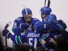 Vancouver Canucks' Alexandre Burrows celebrates teammate Chris Tanev's game-winning goal against the Calgary Flames on Feb. 18, 2017. (THE CANADIAN PRESS/Ben Nelms)