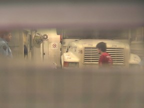 A security guard, left, watches Alexandre Bissonnette as he walks out of a transport bus at the hall of justice, Tuesday, February 21, 2017 in Quebec City, in this video frame grab. The case of the man charged with murder in last month's mosque shootings in Quebec City will resume March 30. Bissonnette, 27, appeared in court on Tuesday as the Crown handed over evidence to the defence lawyer. (THE CANADIAN PRESS/Jean-Vincent Verville)