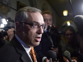 Tony Clement fields questions in the foyer outside the House of Commons in Ottawa, Monday, May 11, 2015. Conservative public safety critic Clement is asking for an apology from the CBC after he hung up the phone during a live radio interview about refugees. THE CANADIAN PRESS/Adrian Wyld