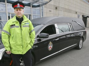 Toronto police Const. Clint Stibbe  stands next to a hearse on Tuesday, Feb. 21, 2017. Police plan to crack down on drivers using hand-held devices while driving. The hearse will be out on the streets along with stealth and fully marked police vehicles as a part of "That Text or Call Could End It All," safety campaign. (Veronica Henri/Toronto Sun)