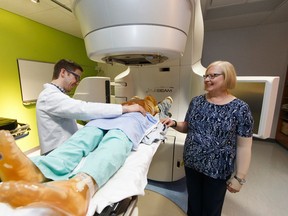 Radiation therapy student Merrill Singleton and volunteer patient and cancer survivor Jill Doiron pose for a photo with the linear accelerator inside the University of Alberta's new radiation therapy training suite at the Cross Cancer Institutre in Edmonton on Tuesday, February 21, 2017. Ian Kucerak/Postmedia