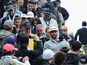 Dustin Johnson and his son Tatum walk down to the 18th hole during the final round at the Genesis Open at Riviera Country Club on Feb. 19, 2017. (Harry How/Getty Images)