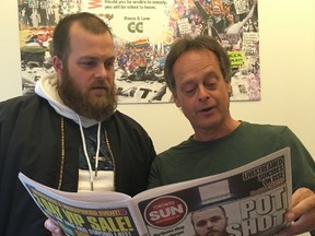 Cannabis Culture owner Mark Emery (right), the city's self-proclaimed Prince of Pot, and Weed the North owner Cory Stoneham, now jokingly referring to himself as the King of Cannabis, peruse the front-page story on marijuana dispensaries in Tuesday's Toronto Sun. (Chris Doucette/Toronto Sun)
