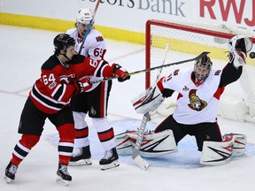 New Jersey Devils left wing Joseph Blandisi tries to deflect a shot as Ottawa Senators goalie Craig Anderson protects his net during an NHL game on Feb. 21, 2017. (AP Photo/Julio Cortez)