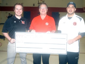 Wallaceburg Red Devils president Rob Pollock, left, and Red Devils coach Justin Durston, right, accept a $2,500 donation sponsorship from Wallaceburg Kinsmen Sheldon Parsons at the D.A. Gordon gym on Saturday.