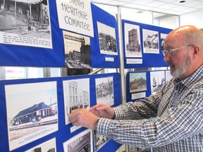 Wayne Wager, chairperson of the Sarnia Heritage Committee, places a photo on the group's display on Wednesday in the lobby at City Hall in Sarnia, Ont. The committee will also be part of a Heritage Week display at Lambton Mall, Thursday through Sunday. (Paul Morden/Sarnia Observer)