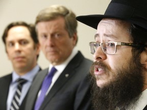 B'nai Brith Canada CEO Michael Mostyn (left), and Toronto Mayor John Tory listens to Rabbi Moshe Steiner of Uptown Chabad speak about fighting anti-semitism during a news conference at Toronto police's 32 Division in North York on Wednesday, Feb. 22, 2017. (MICHAEL PEAKE/TORONTO SUN)