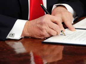 In this Feb. 3, 2017, photo, President Donald Trump signs an executive order in the Oval Office of the White House in Washington. (AP Photo/Pablo Martinez Monsivais)