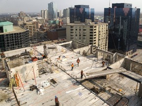 Tricar construction workers place a section of floor onto the 17th level of the Azure Tower being built at Dufferin Avenue and Talbot Street. The precast concrete slabs are hoisted into position by crane operator Paul Santos, perched more than 92 metres up. (MIKE HENSEN, The London Free Press)